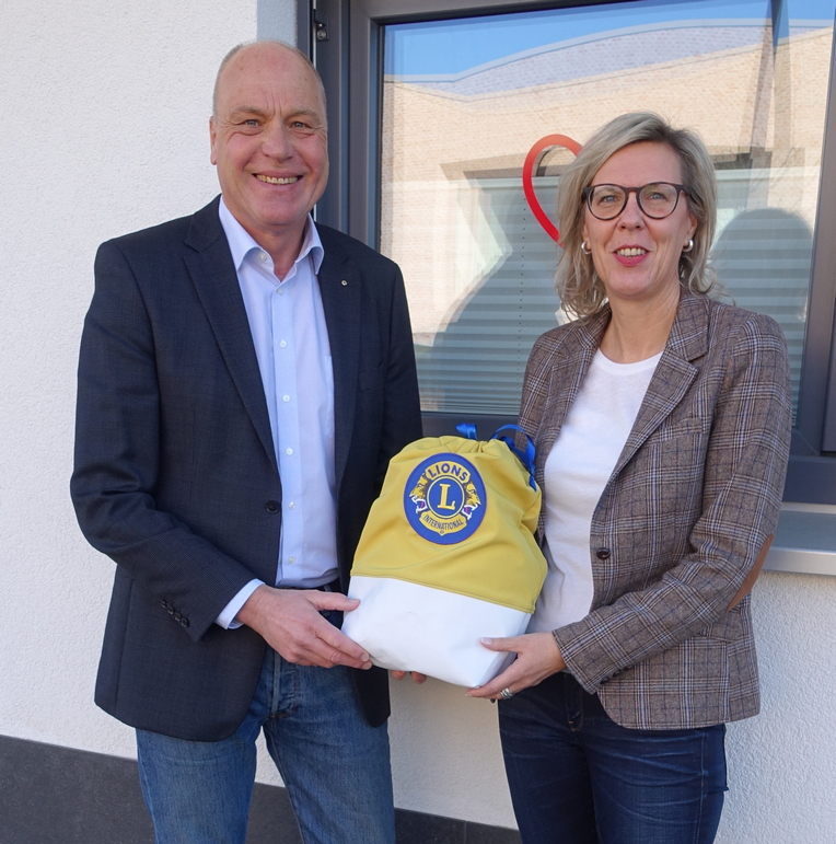 Bild zeigt: Präsident Bernd Boolzen übergibt 2000 Euro im Spendensäckchen an Frau Kathrin Stumpf